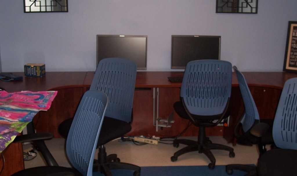 Two chairs are in front of two computers.